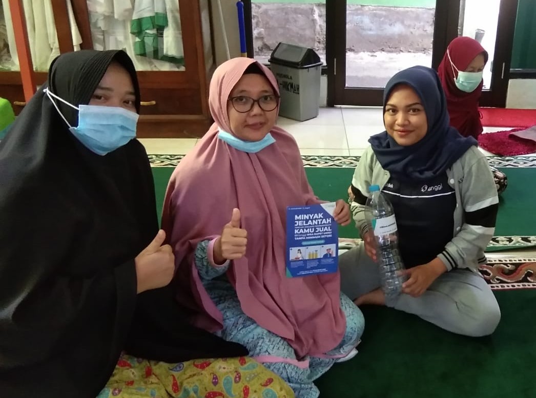 A Langgi agent educating local residents about selling used cooking oil